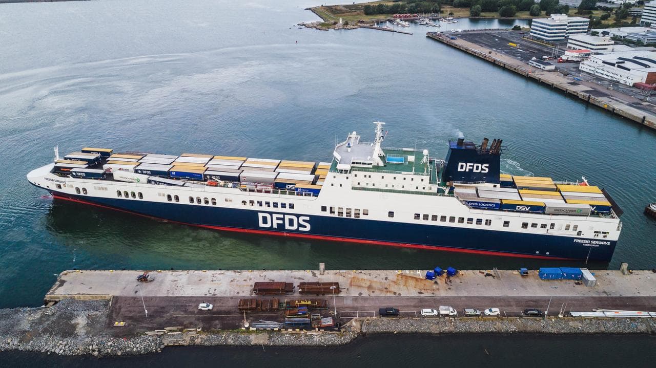 DFDS ship at port loaded with cargo trailers.