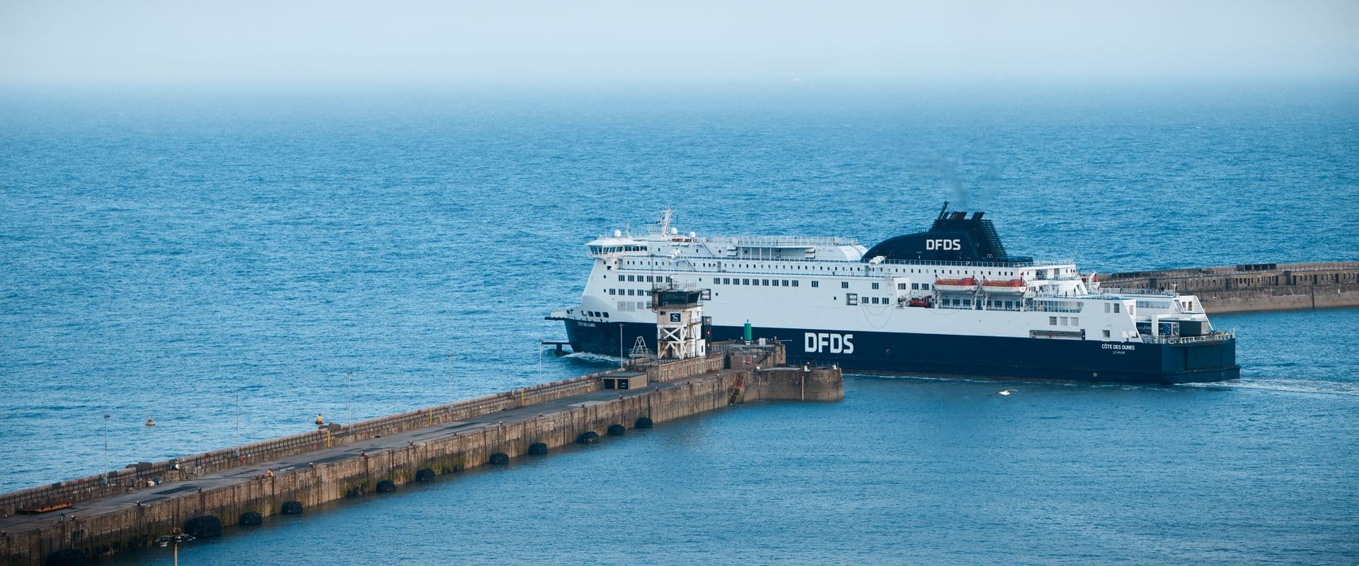 DFDS vessel Cote des Dunes, with a new funnel, sailed out of the harbour on a clear sea