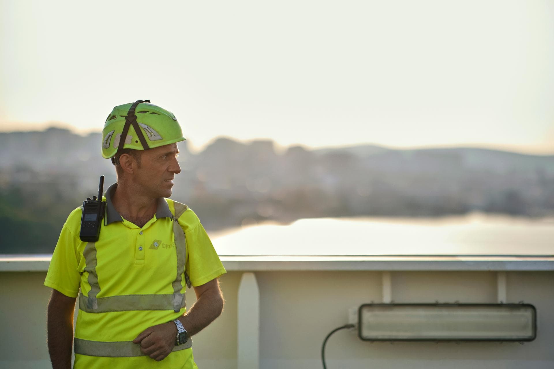 DFDS employee, with yellow helmet & shirt, standing on board of a vessel