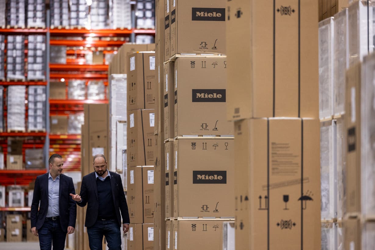 DFDS and Miele colleagues walking together in a DFDS warehouse among Miele's product.