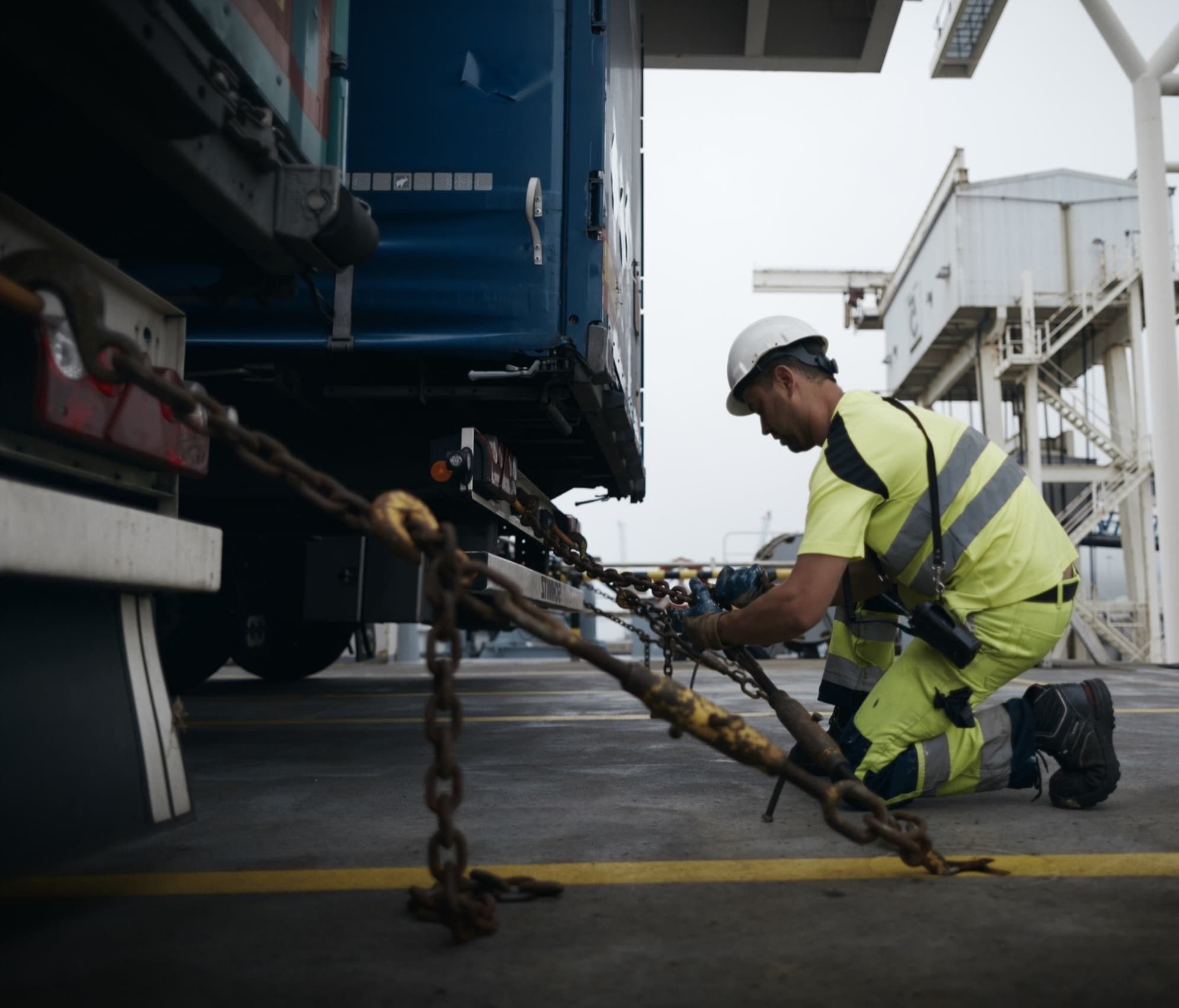 Photo of a DFDS Logistics worker tying down a truck to the ground